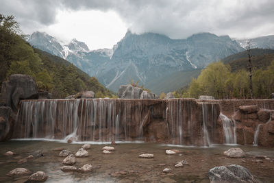 Scenic view of waterfall against sky