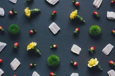 High angle view of flowers with fruits and leaf arranged on table