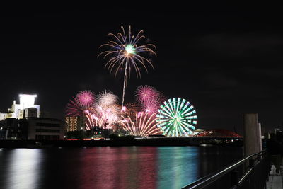 Firework display over river at night