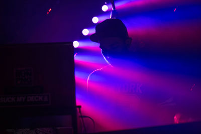 Man working on illuminated street light at night