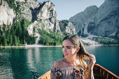 Portrait of woman by lake against mountains