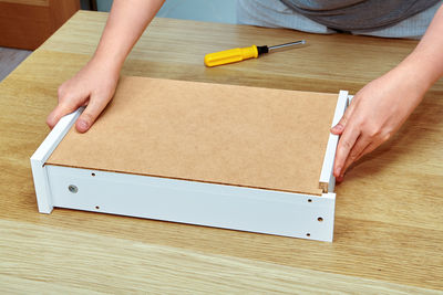 High angle view of person hand holding paper on table