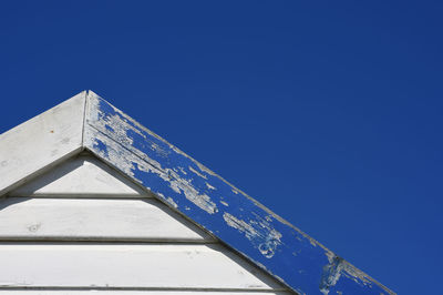 Low angle view of text on building against clear blue sky