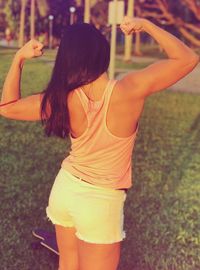Rear view of young woman holding mobile phone