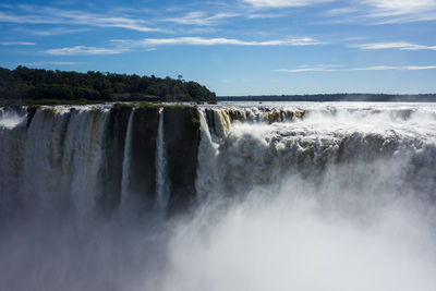 Scenic view of waterfall against sky