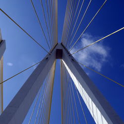 Low angle view of suspension bridge against blue sky