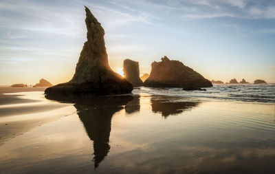 Rock formation on beach against sky