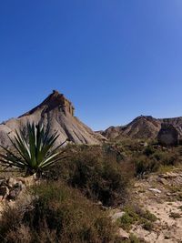 Scenic view of rocky mountain against clear blue sky
