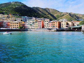 Boats in sea with buildings in background