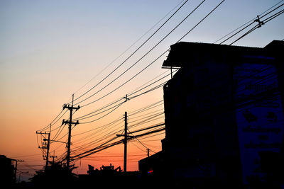 Low angle view silhouette electricity pylon against sky during sunset