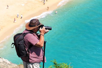 View of man photographing beach from cliff