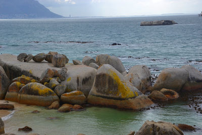 Rocks on sea shore against sky