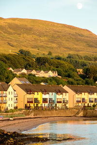 Houses by buildings against sky