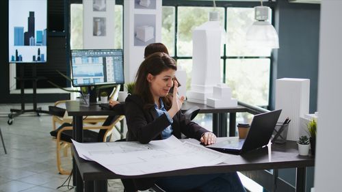 Side view of businesswoman using laptop at office