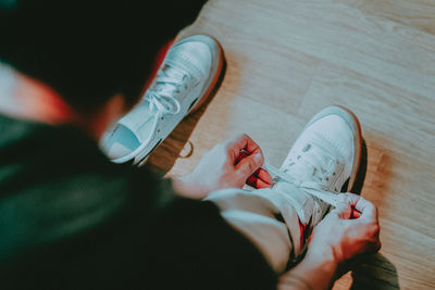 Low section of people sitting on wooden floor