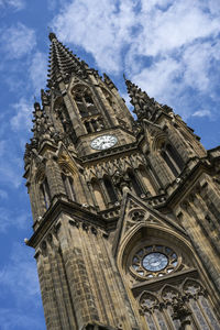 Low angle view of clock tower against cloudy sky