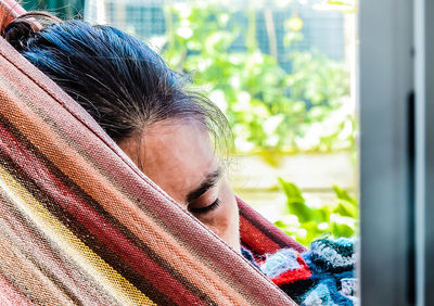 Close-up portrait of woman sleeping in window