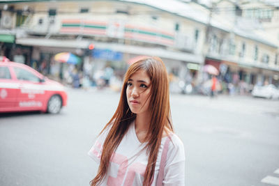 Portrait of young woman on street in city