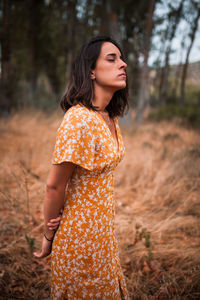 Beautiful young woman with closed eyes standing in forest