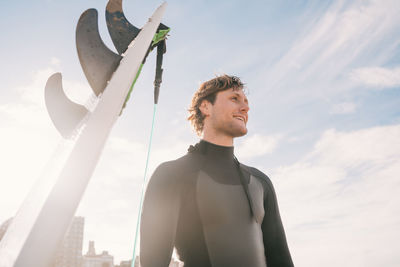 Low angle view of man looking away against sky