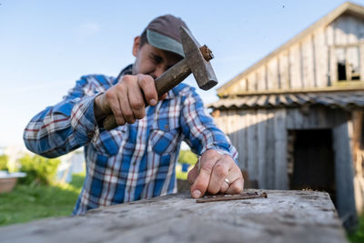 Carpenter using hammer outdoors