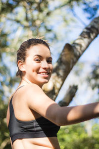 Portrait of teenage girl exercising in park