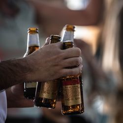 Midsection of man holding beer glass