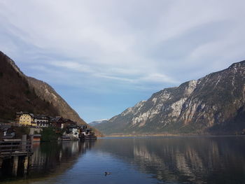 Scenic view of lake by mountains against sky