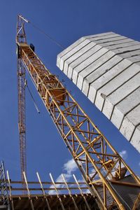 Low angle view of crane against sky