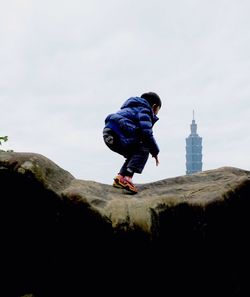 Low angle view of woman standing against clear sky