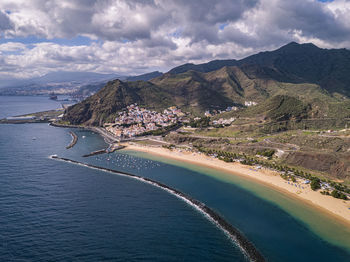 Scenic view of sea and mountains against sky