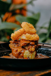 Beef and salmon on a black plate in black pepper sauce