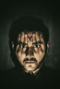 Digital composite portrait of man covering face with hands