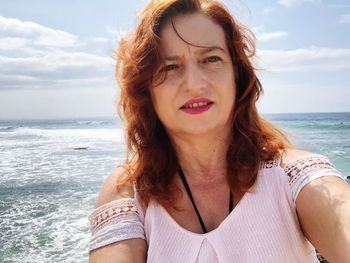 Portrait of woman at beach against sky