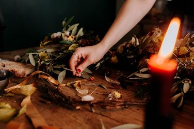 Cropped image of woman making flower decoration on table