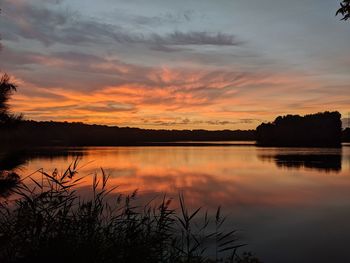 Scenic view of lake against orange sky