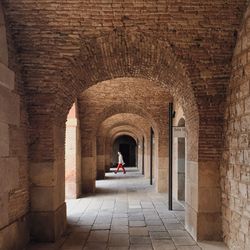 Rear view of woman walking in archway