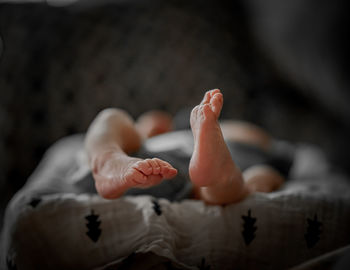 Low section of child lying on bed