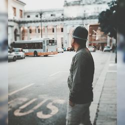 Rear view of man standing on street in city