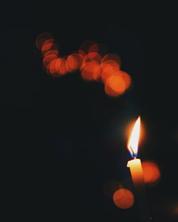 Close-up of illuminated candle against black background