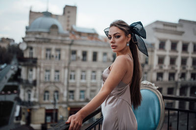 Young woman standing against building in city