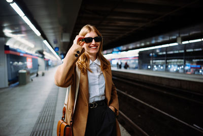 Portrait of young woman standing in city