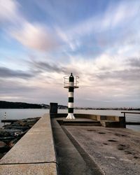 Lighthouse by sea against sky