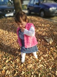 Girl standing by autumn leaves