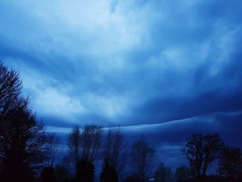 Low angle view of silhouette trees against sky at dusk