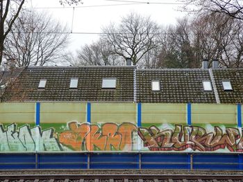 Graffiti on built structure against bare trees