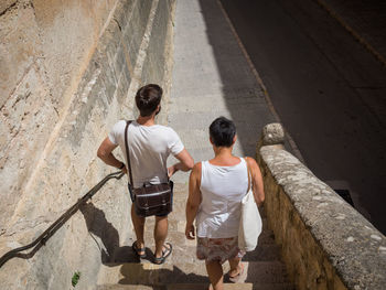 Rear view of people walking down stairs in city, manacor, spain