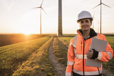 Smiling engineer with digital tablet at wind park