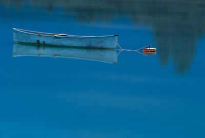 Boat moored on lake during sunset