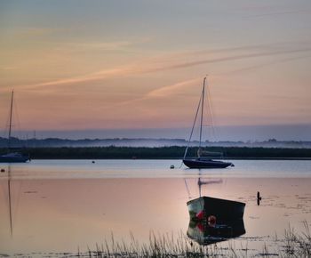 View of boats in calm sea at sunset